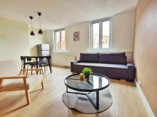 ein Wohnzimmer mit einem Sofa und einem Tisch in der Unterkunft Le Contemporain (Centre - Gare - Commerces) in Lens