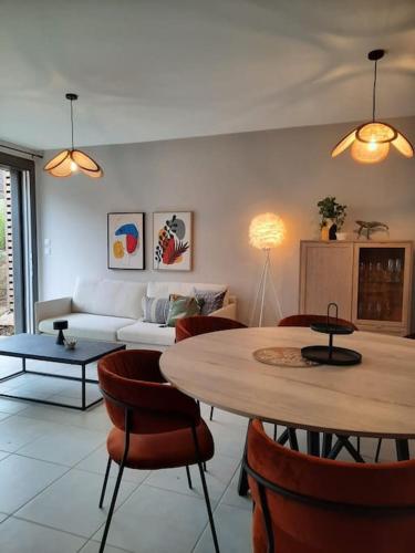 ein Wohnzimmer mit Tisch und Couch in der Unterkunft Le Spicy 2 minutes centre historique parking in Sarlat-la-Canéda