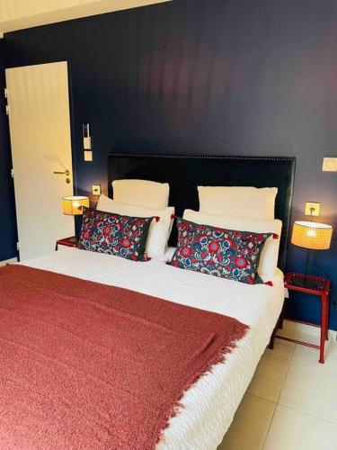 ein Schlafzimmer mit einem Bett mit einer roten Decke und Kissen in der Unterkunft Le Spicy 2 minutes centre historique parking in Sarlat-la-Canéda