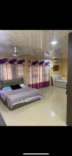 1 dormitorio con 1 cama grande y cortinas moradas en HOMESTAY MDRS TAMAN DESA BIDARA, en Kuala Ketil