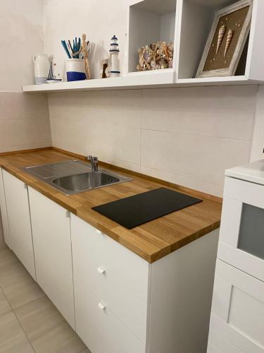 a kitchen with a sink and a wooden counter top at Casa Tua - Sea View Chianca in Vieste