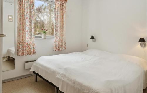 1 dormitorio con cama blanca y ventana en Gorgeous Home In Stege With Kitchen, en Stege