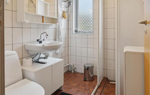 Baño blanco con lavabo y aseo en Gorgeous Home In Stege With Kitchen, en Stege