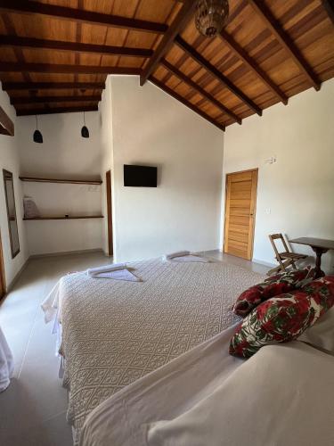 a bedroom with a large bed and a table at La Bella Suítes in Ilhabela