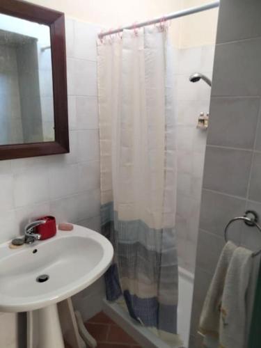 a bathroom with a sink and a shower with a shower curtain at Casa Nana' in Carpignano Sesia