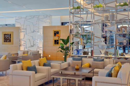 a lobby with white couches and yellow and blue pillows at Hilton Dubai Palm Jumeirah in Dubai