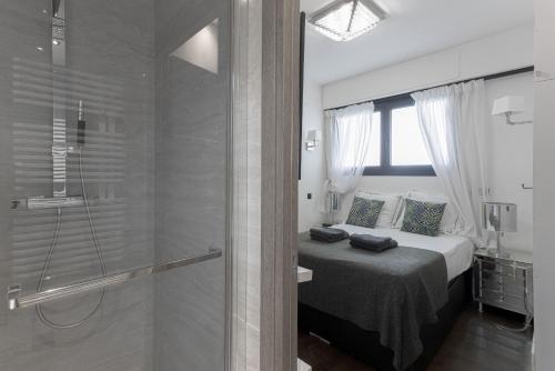 a bedroom with a bed and a glass shower at Palais Des Iles - La Croisette in Cannes