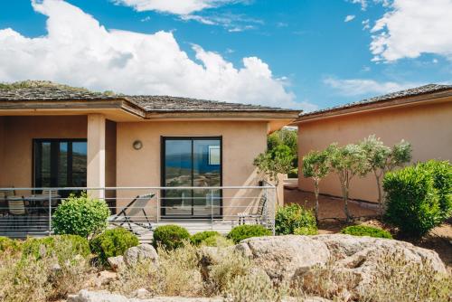 a house with a balcony with a view at Résidence Les Terrasses de Rondinara in Bonifacio