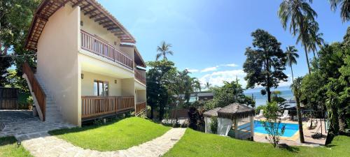 an external view of a house with a swimming pool at La Bella Suítes in Ilhabela