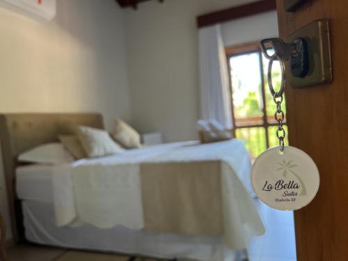 a bedroom with a bed and a door with a key at La Bella Suítes in Ilhabela