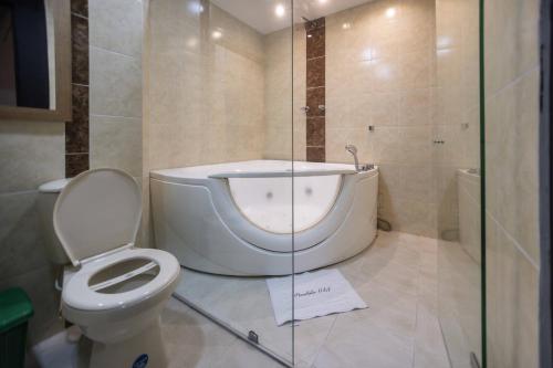 a bathroom with a toilet and a bath tub at Mándala Hotel Belén in Medellín