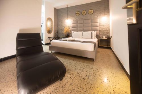 1 dormitorio grande con 1 cama y 1 sofá en Mándala Hotel Belén, en Medellín