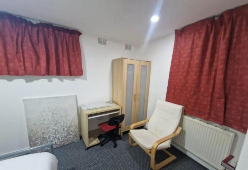 a room with a chair and a desk and a red curtain at Classic Studio near Headingley Stadium in Headingley