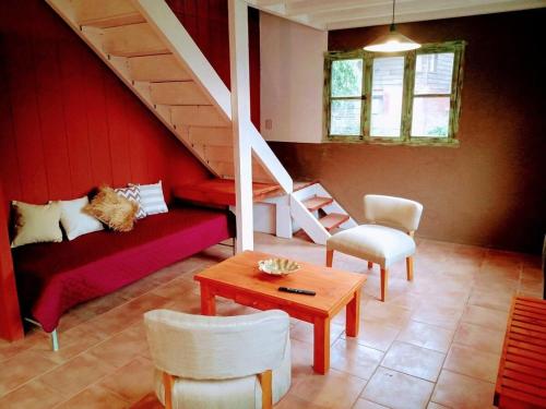 ein Wohnzimmer mit einem roten Sofa und einer Treppe in der Unterkunft Mi Casa Tu Casa in Lago Puelo