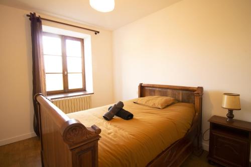 a teddy bear sitting on a bed in a bedroom at Ferme Bressane - 4 chambres in Saint-Étienne-du-Bois