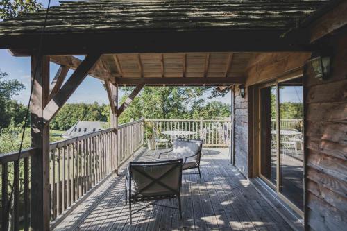 - une terrasse couverte en bois avec une chaise sur la terrasse dans l'établissement Chateau d'Audrieu, à Audrieu