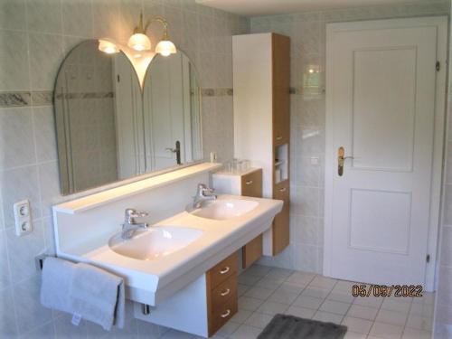 a bathroom with two sinks and a large mirror at Landhaus Maria in Velden am Wörthersee