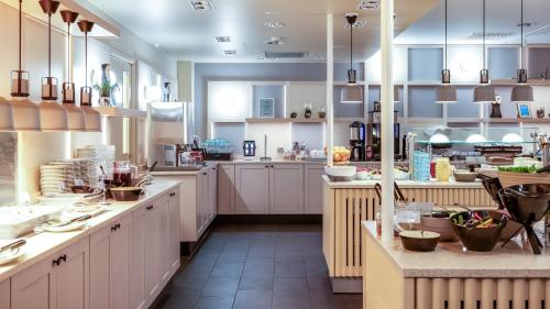 a large kitchen with white cabinets and counters at Break Sokos Hotel Levi in Levi