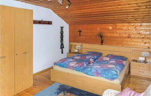 a bedroom with a bed and a wooden wall at Amazing Apartment In Schetteregg With House A Mountain View in Egg