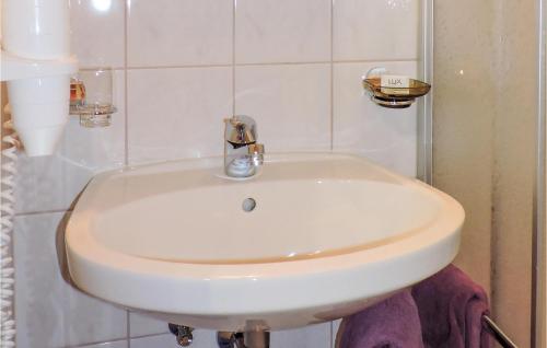 ein weißes Waschbecken in einem weiß gefliesten Bad in der Unterkunft 1 Bedroom Lovely Apartment In Kappl in Kappl