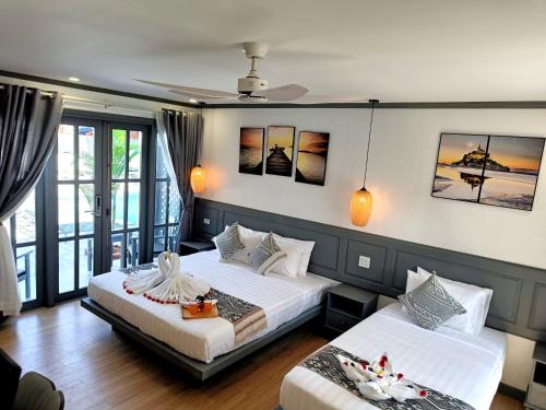 a bedroom with two beds and a balcony at LuangPrabang Pearl Hotel in Luang Prabang