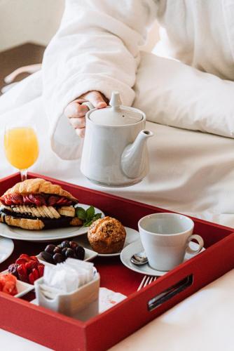 a tray of breakfast foods and coffee on a bed at Hilton Garden Inn Tucuman in San Miguel de Tucumán