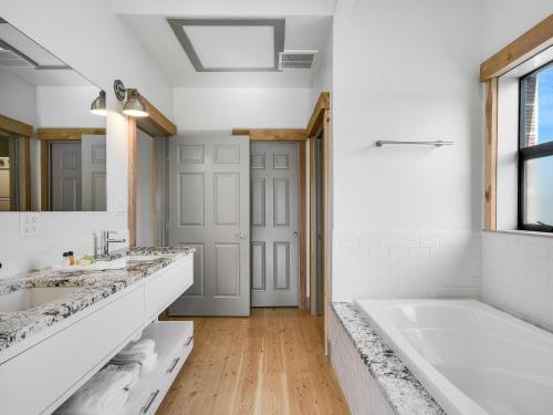 a white bathroom with two sinks and a tub at GARDENS OF BARONS CREEK UNIT A in Fredericksburg