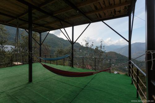 a hammock on a balcony with a view of mountains at Hill Wonder in Batumi