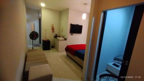 een slaapkamer met een rood bed en een televisie bij Apartamento central particular in Lavras