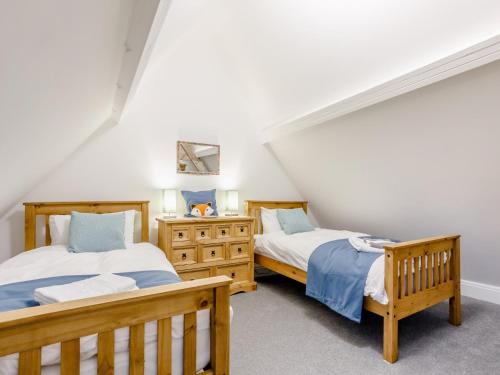 two beds in a attic bedroom with white walls at 6 Bed in Blandford Forum 80549 in Milborne Saint Andrew