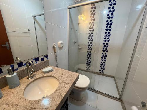 a bathroom with a toilet and a sink and a shower at Apto 2 Quartos - Prédio de Frente para o Mar - Sem Vista in Guarapari