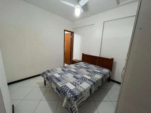 a bedroom with a bed with a quilt on it at Apto 2 Quartos - Prédio de Frente para o Mar - Sem Vista in Guarapari