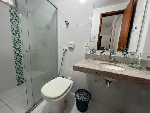 a bathroom with a toilet and a sink and a shower at Apto 2 Quartos - Prédio de Frente para o Mar - Sem Vista in Guarapari