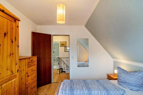 Un dormitorio con una cama, una cómoda y un espejo. en Ferienhaus Diekster - Obergeschoss, en Norddeich