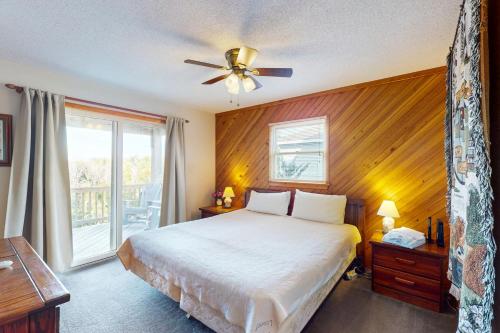 a bedroom with a bed and a ceiling fan at Nothern Comfort 85 in Waves