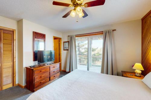 a bedroom with a bed with a ceiling fan and a television at Nothern Comfort 85 in Waves