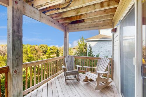 a porch with two rocking chairs on a house at Nothern Comfort 85 in Waves