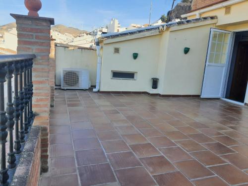 a balcony with a brick floor and a white building at Dúplex Caminito de Ardales in Ardales