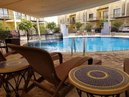 einen Tisch und Stühle vor einem Pool in der Unterkunft Perfect Vacation with 3bhk villa in Dubai