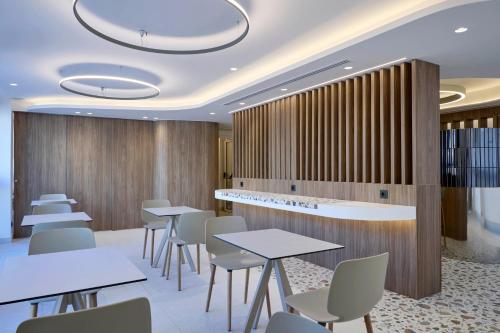 a restaurant with tables and chairs and a bar at Twinn Downtown Piraeus, Santikos Collection in Piraeus