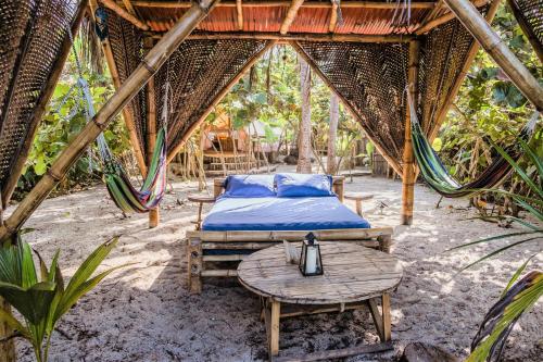 a bed and a table and a hammock in a tent at Lote 10 Glamping in Guachaca