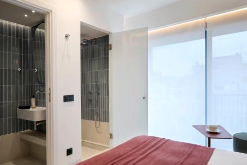 een slaapkamer met een bed, een douche en een wastafel bij Twinn Downtown Piraeus in Piraeus