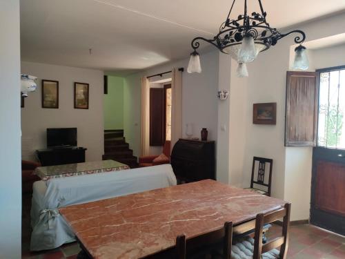 Una sala de estar con una mesa y una lámpara de araña. en Chalet Rafael Constantina, en Constantina