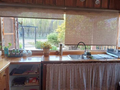 a kitchen counter with a sink and a window at Sentidos Cardinales in Perito Moreno
