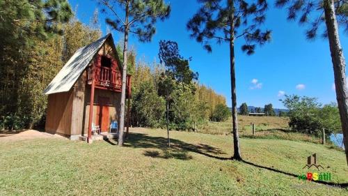 une petite cabane en bois dans un champ arboré dans l'établissement H Office x WiFi x Churrasqueira x 6km Estr do Mar x 7km Pq de Rodeio x 12km Morro Borrusia, à Osório