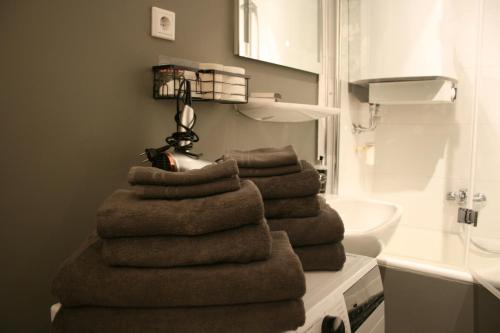 une pile de serviettes assises sur un comptoir dans la salle de bains dans l'établissement Apartment Prinz Leopold - Zentral - Zimmerprinzen, à Oldenbourg