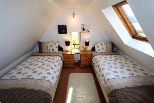 a attic room with two beds and a mirror at The Lodge in Lochgilphead