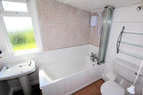 y baño con bañera, lavabo y aseo. en The Lodge, en Lochgilphead