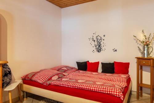 a bedroom with a bed with red pillows at Schwarzwald Nescht Triberg in Triberg