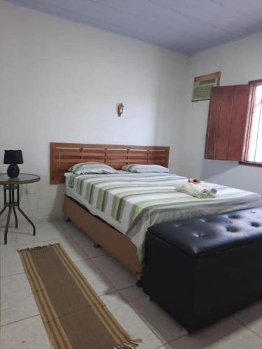 a bedroom with a large bed and a table at Casa Villa Mariah - São Miguel dos Milagres - PATACHO, PORTO DE PEDRAS in Pôrto de Pedras